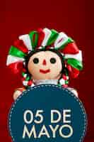 Foto gratuita simpatica bambola messicana con in mano il segno del 5 maggio