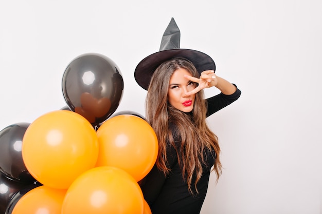 Cute model enjoying halloween photoshoot on white wall