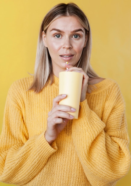 Бесплатное фото Симпатичная модель с желтым напитком
