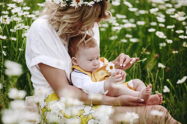 cute mom and baby in camomile field