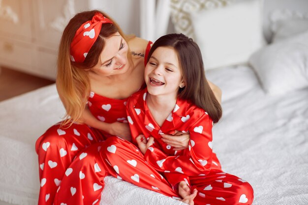 Cute mother and daughter at home in a pajamas