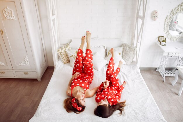 Cute mother and daughter at home in a pajamas