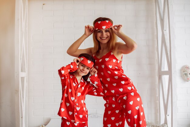 Cute mother and daughter at home in a pajamas