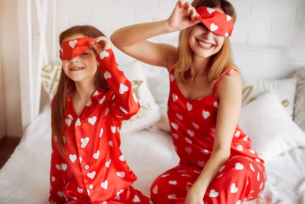 Cute mother and daughter at home in a pajamas