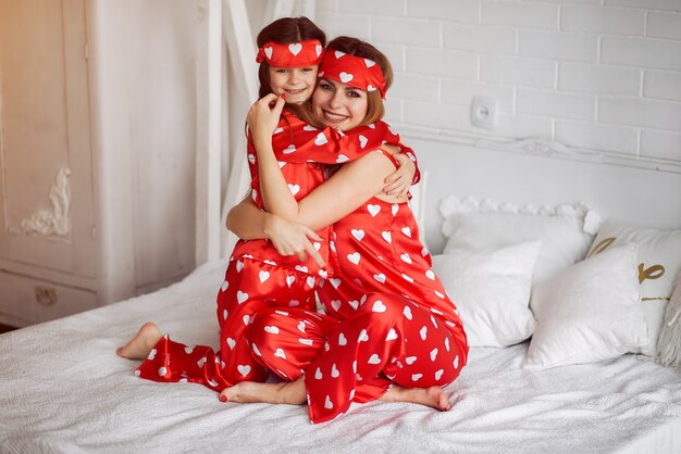 Cute mother and daughter at home in a pajamas