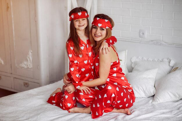 Cute mother and daughter at home in a pajamas