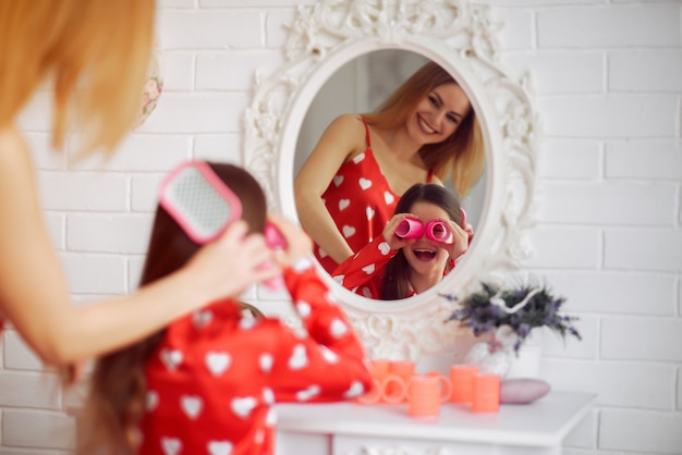 Free photo cute mother and daughter at home in a pajamas