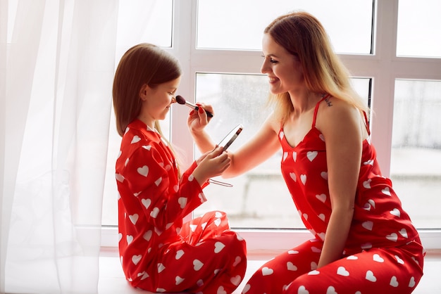 Cute mother and daughter at home in a pajamas