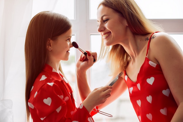 Cute mother and daughter at home in a pajamas