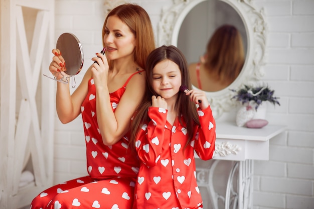 Cute mother and daughter at home in a pajamas