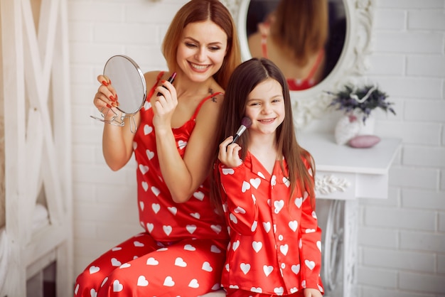 Cute mother and daughter at home in a pajamas