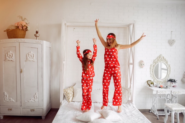 Free photo cute mother and daughter at home in a pajamas