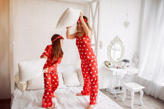 Cute mother and daughter at home in a pajamas