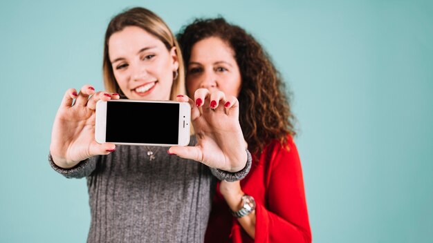 Cute mother and daughter taking selfie