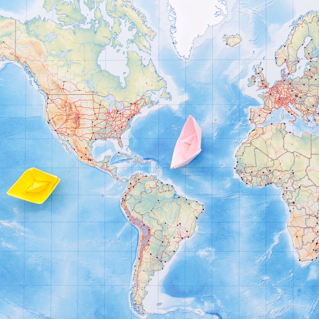 Cute paper boats on map