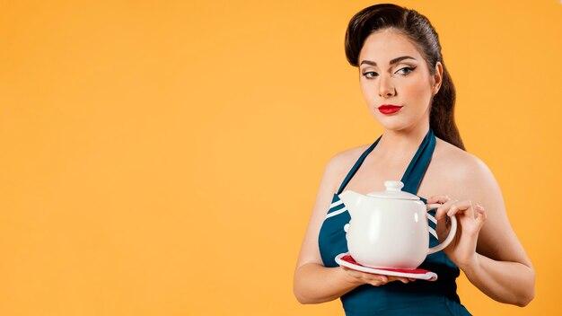 Cute pinup girl holding a teapot