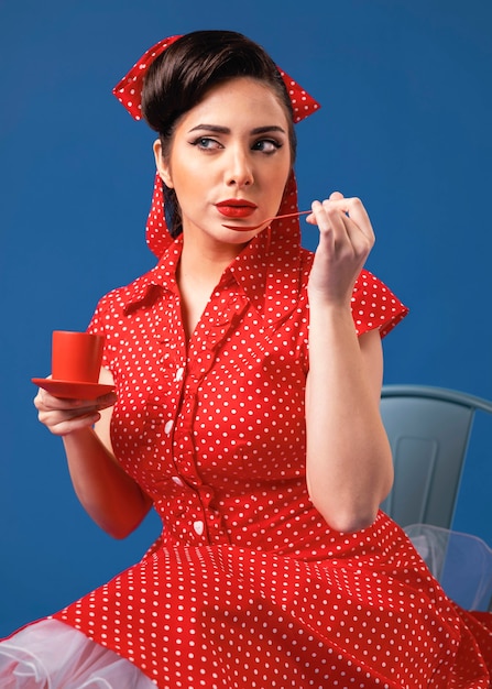 Free photo cute pinup girl posing in a blue studio