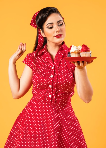 Cute pinup girl posing with cupcakes