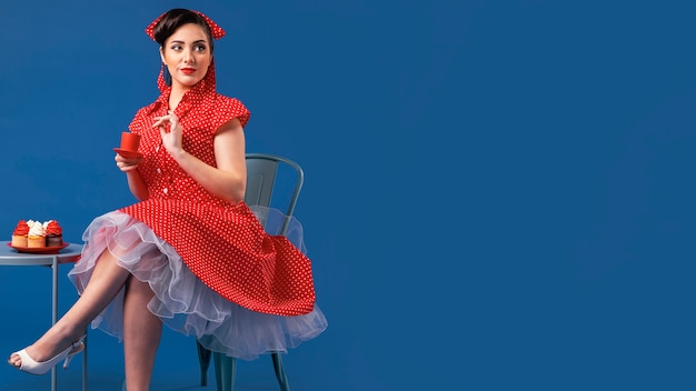 Cute pinup girl posing with cupcakes