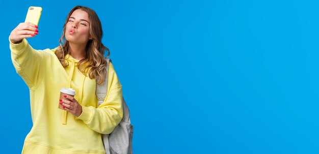 Cute positive and feminine beautiful young female student heading college holding paper cup from fav