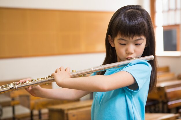 かわいい女の子 教室でフルートを弾く プレミアム写真