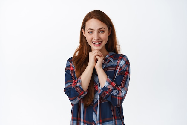 Cute redhead girl with freckles, contemplating standing on white.