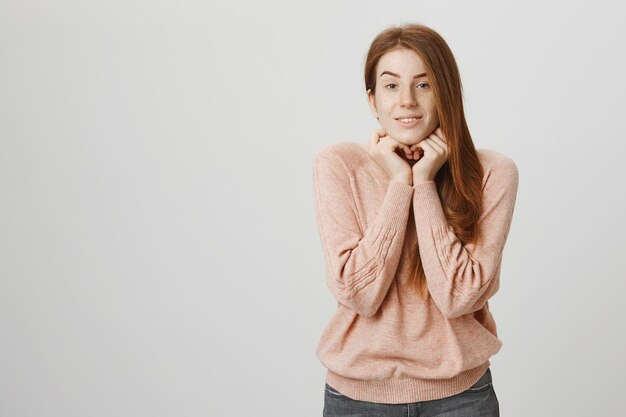 Cute romantic girl with red hair and freckles looking dreamy