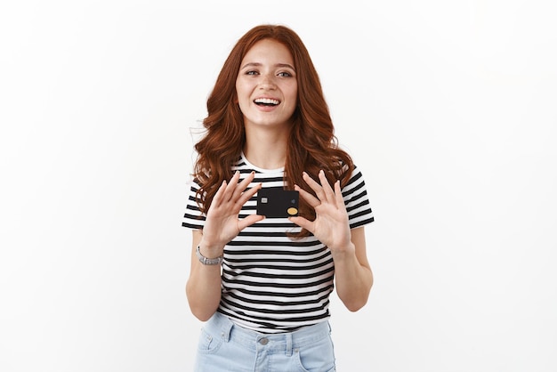 Free photo cute satisfied attractive redhead female freelancer using credit card to transfer money easily paying for online purchases via banking account smiling delighted open deposit gather cashback