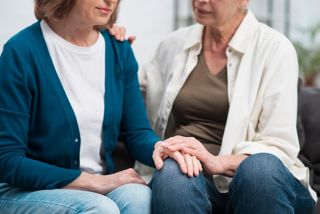 Cute senior women holding hands