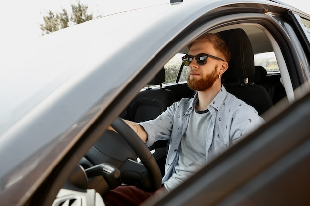 Cute serious young male with thick ginger beard and earrings