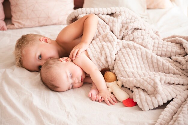 Cute siblings lying on bed