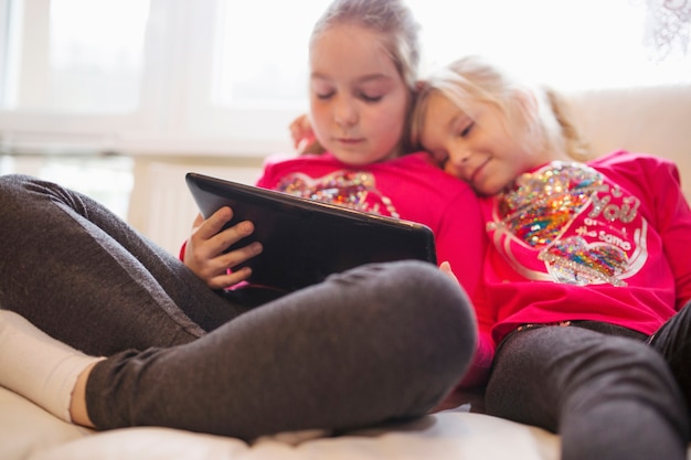 Cute sisters watching video on tablet