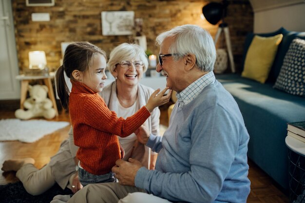 Cute small girl spending time with her grandparents at home