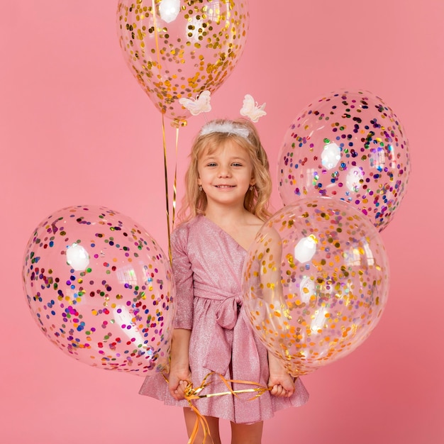 Free photo cute smiley girl with balloons