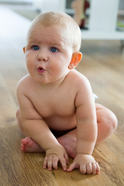 Cute smiling baby sitting at home.