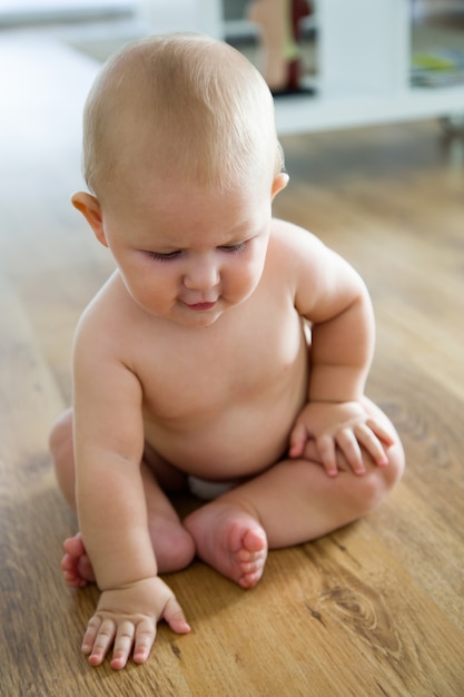 Cute smiling baby sitting at home.