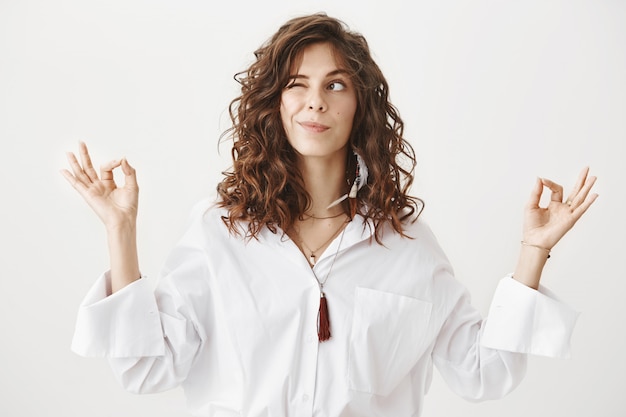 Cute smiling woman meditating and peeking left