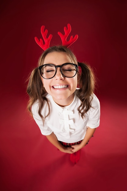 Cute smiling woman with headband with reindeer antlers