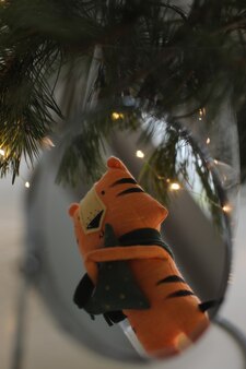 Cute soft toy tiger with decorations on a cozy christmas or new year background symbol of 2022