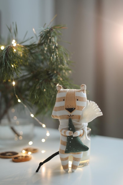 Cute soft toy tiger with decorations on a cozy christmas or new year background symbol of 2022