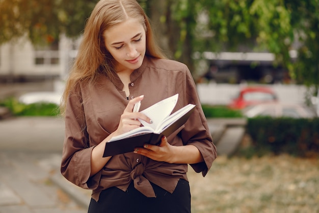 Cute student working in a park and use the notebook