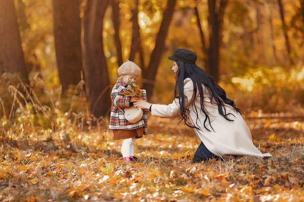 Famiglia carina ed elegante in un parco in autunno