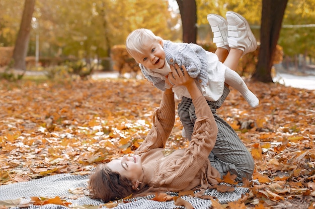 Famiglia carina ed elegante in un parco in autunno