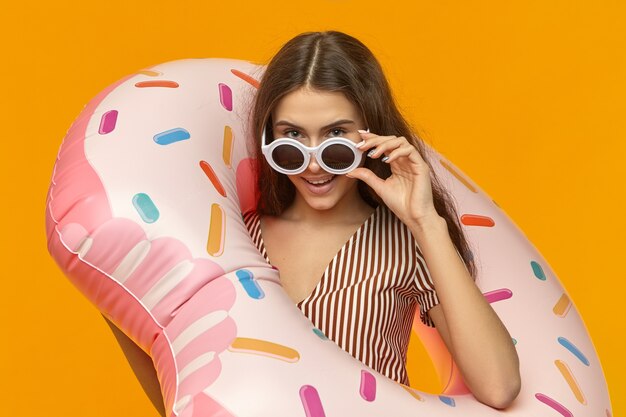 Cute stylish pretty girl in round shades having fun during summer vacations at seaside