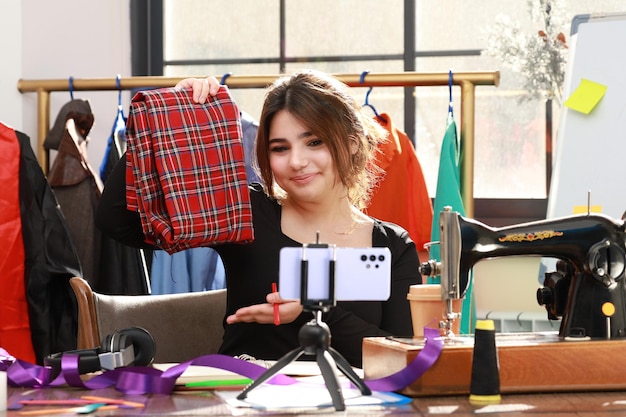 Free photo cute tailor showing her fabric to the phone