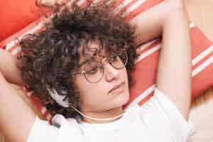 Free photo cute teenager listening to music on floor