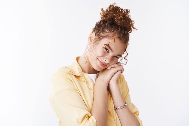 Free photo cute tender feminine pretty redhead european woman  tilting head lean palms smiling blushing feel touched heartwarmed