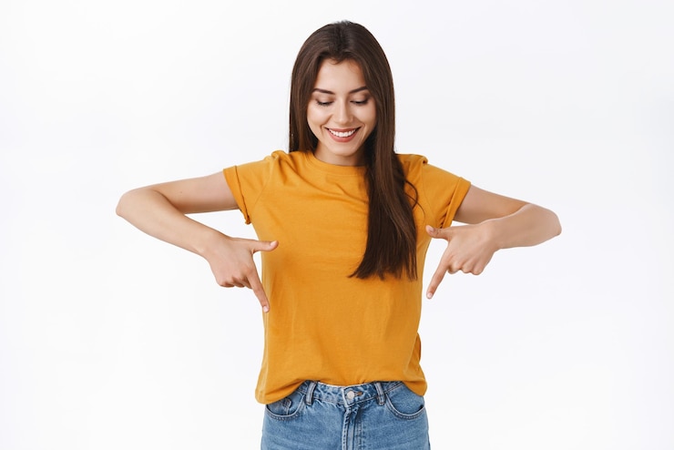 Free Photo cute tender gorgeous brunette female in yellow tshirt looking and pointing up standing amused and wondered observe cool event checking out good promo or taking part awesome giveaway
