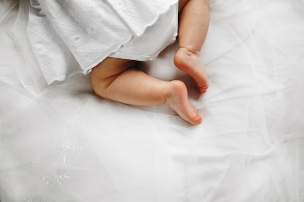 침대에 여자 아기의 귀여운 작은 다리