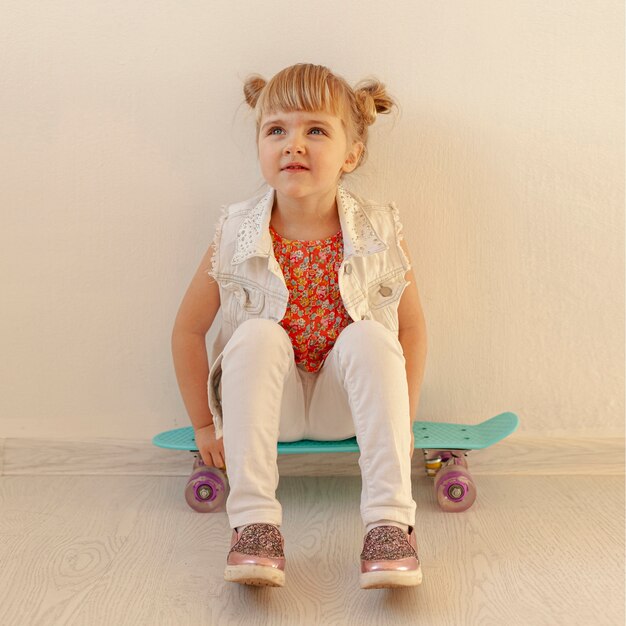 Cute toddler posing on skateboard